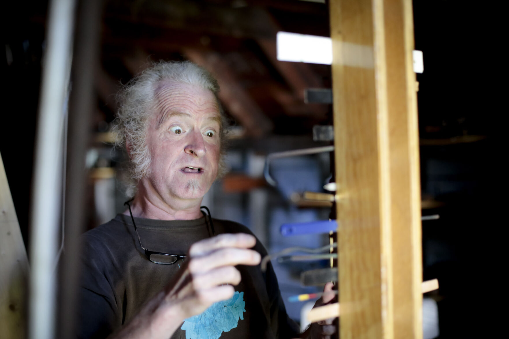 man flicks objects attached to upright board with surprised look